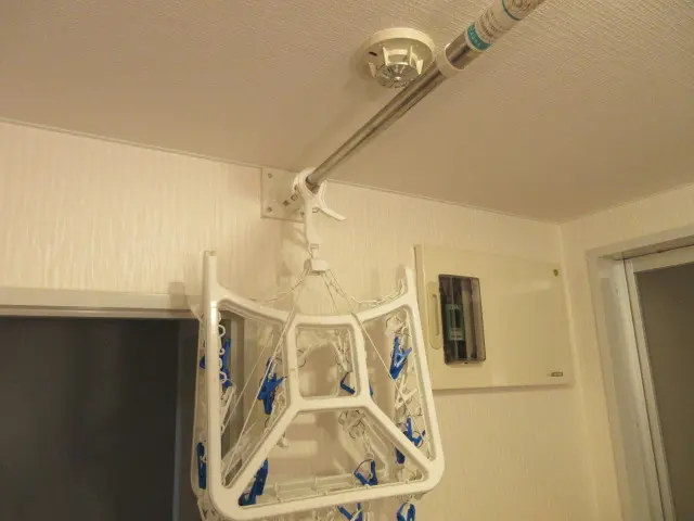 自作した物干し器具に物干し竿を掛けて使う様子