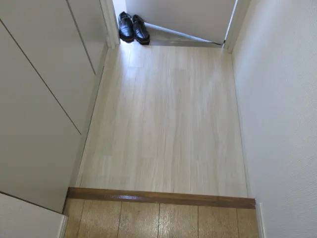壁紙と床に白系の建材を使用して全体的に明るくなった玄関