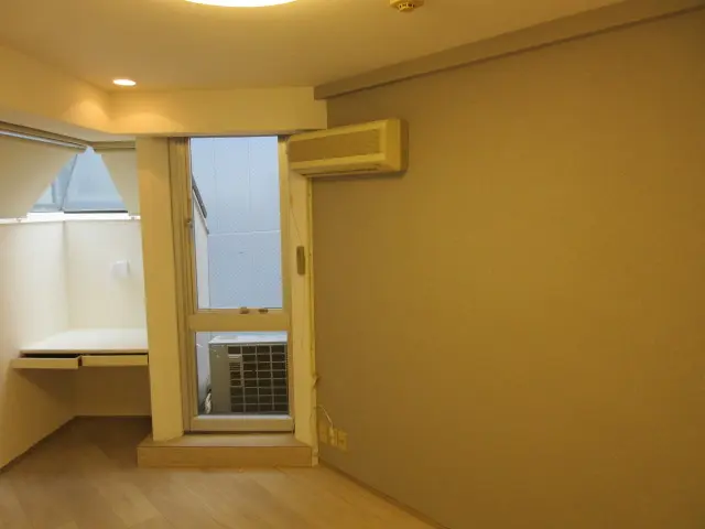 グレーのアクセントクロスとウッドタイルがポイントの原状回復後の部屋