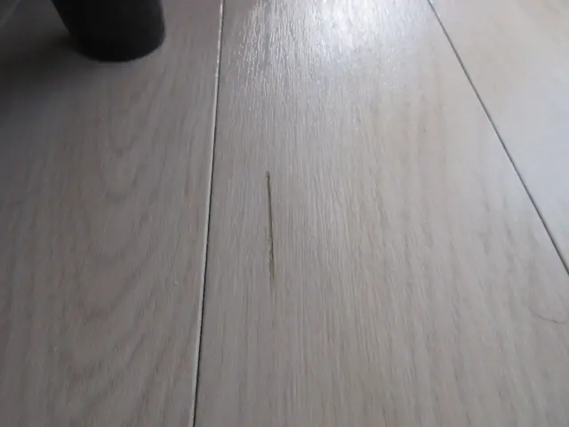 ウッドタイルの床についた少し長めのキズがある様子