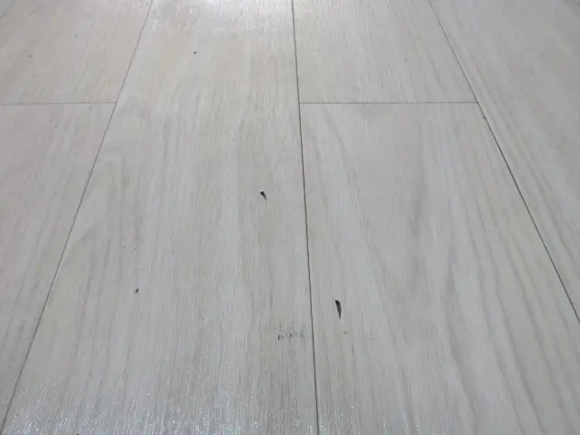 ウッドタイルの床に小さな陥没キズがある様子