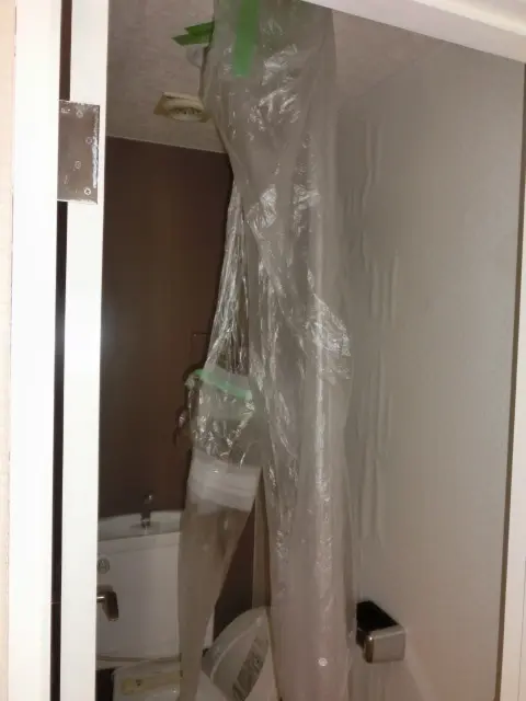 天井からの漏水をビニール養生を使って便器に誘導している状態