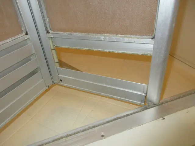 浴室ドアのフレームが本体から外れている様子