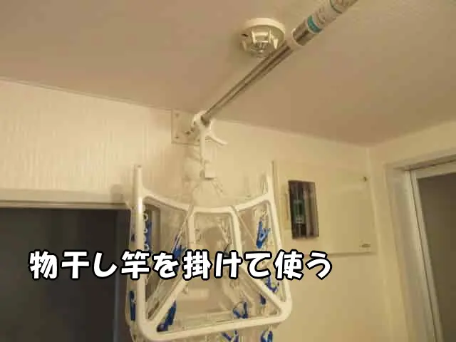自作した物干し器具に物干し竿を掛けて使う様子