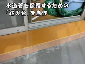 ベランダの水道管を保護するための踏み台を設置した様子