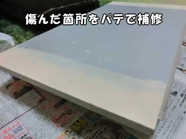収納扉を外し、傷んだ箇所をパテで補修している様子