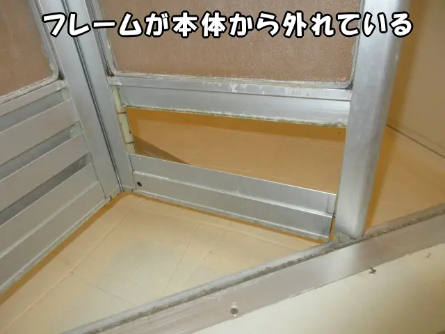 浴室ドアのフレームが本体から外れている様子