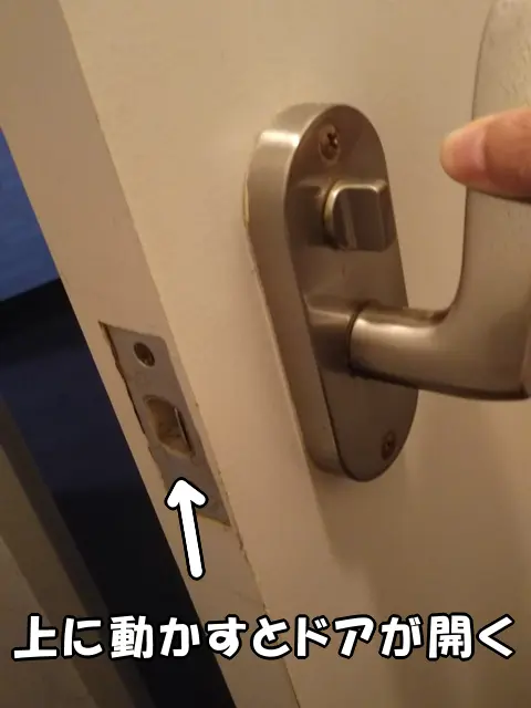 ドアノブを上に動かすとドアが開く様子